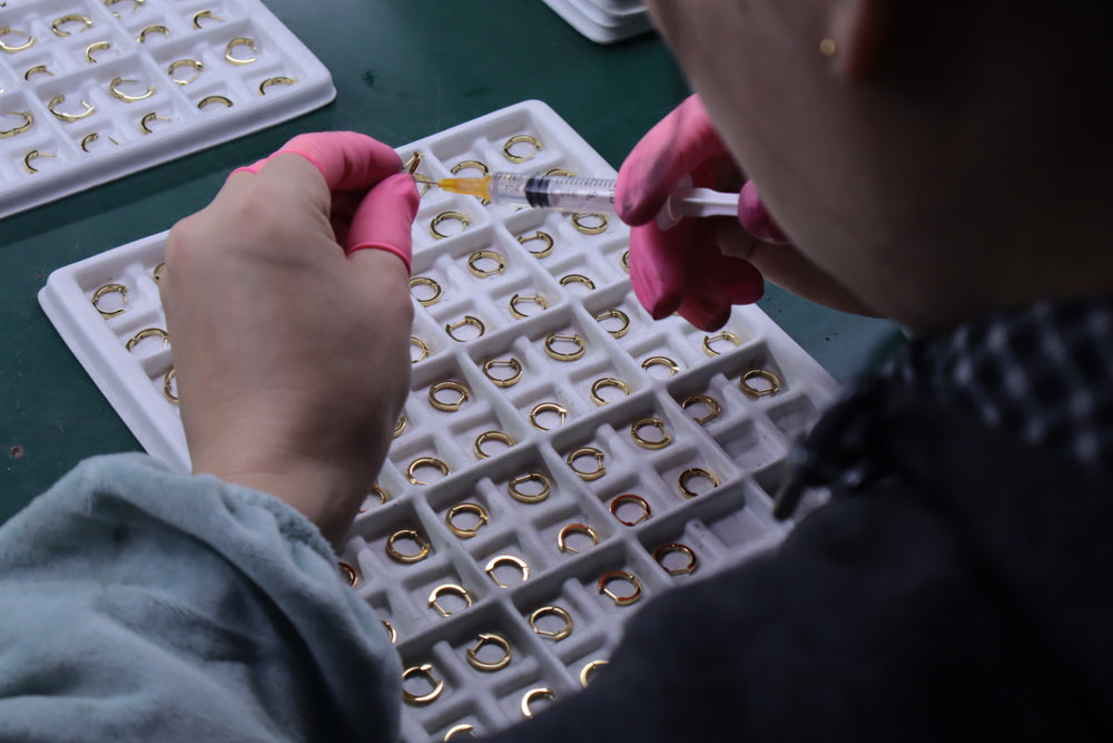 Detailed jewelry assembly and component placement at a workbench