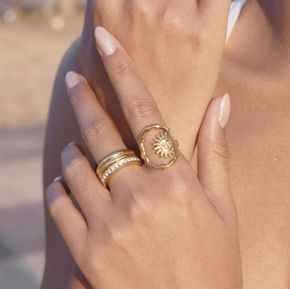Sunburst and celestial rings worn on a hand