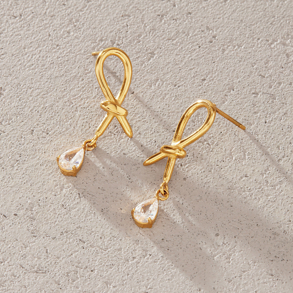 Pair of knotted loop studs on a textured surface