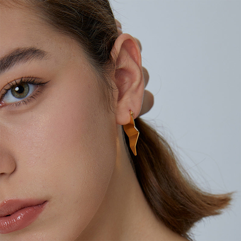 folded geometric gold plated drop earring worn on the ear