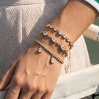 Three clear stone bracelets layered on wrist