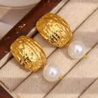 gold plated textured pearl drop earrings arranged on a display tray