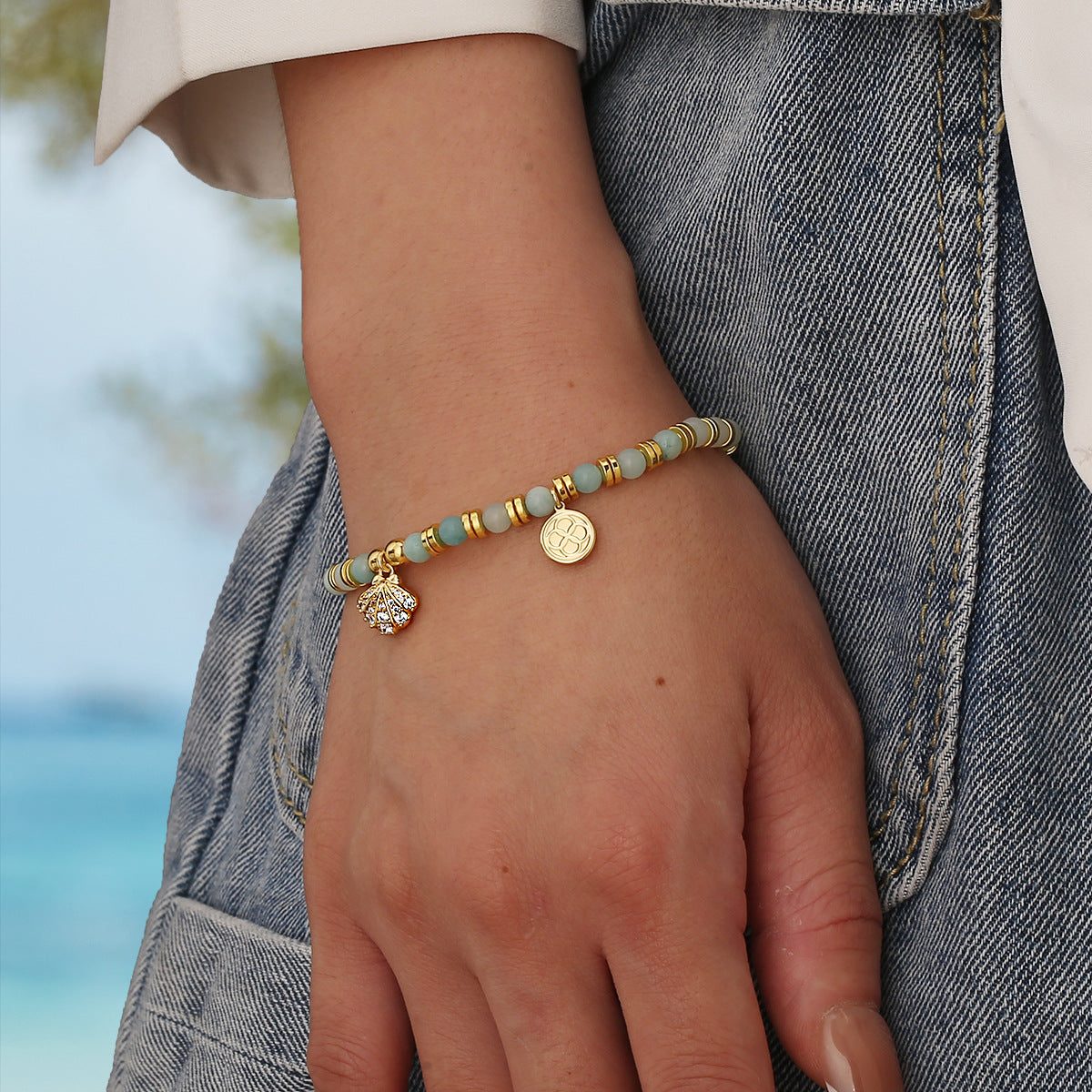 model wearing an aqua and gold plated coastal beaded bracelet