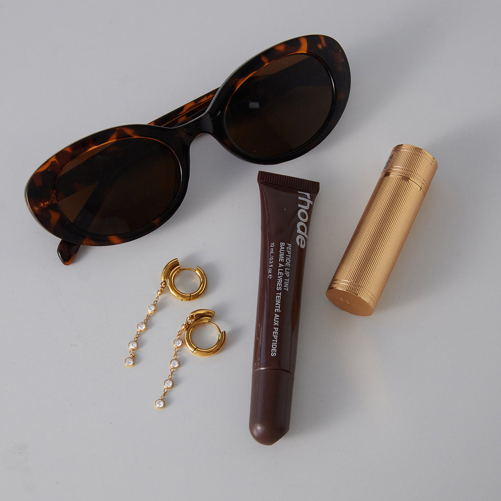 pair of gold plated cascade earrings beside sunglasses
