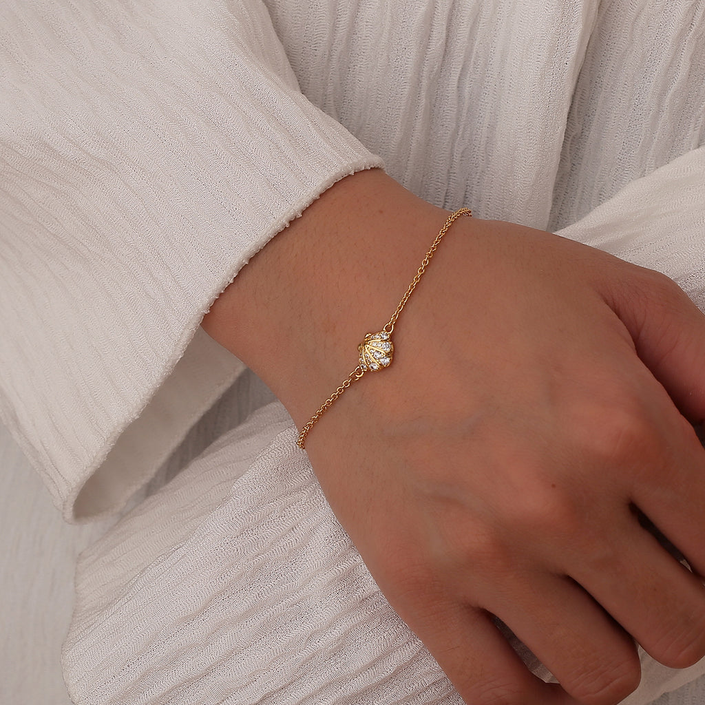 model wearing a fine gold plated seashell chain bracelet