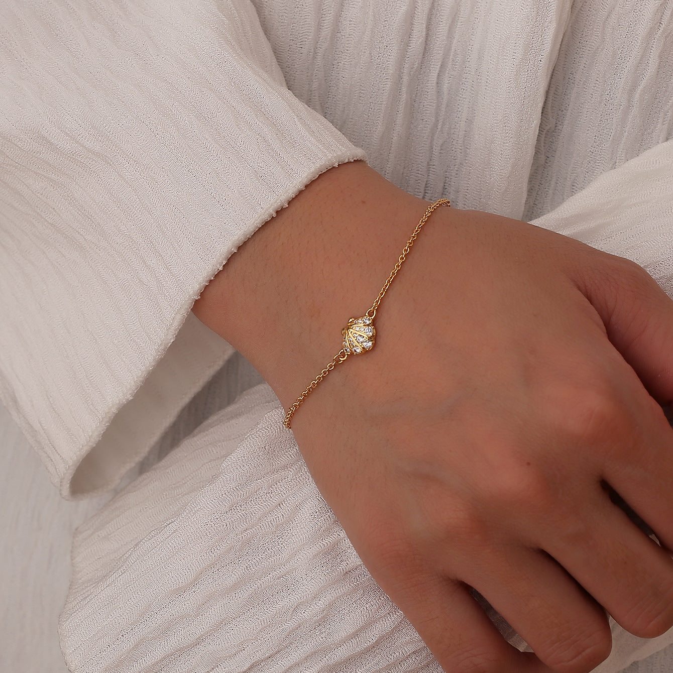 model wearing a fine gold plated seashell chain bracelet