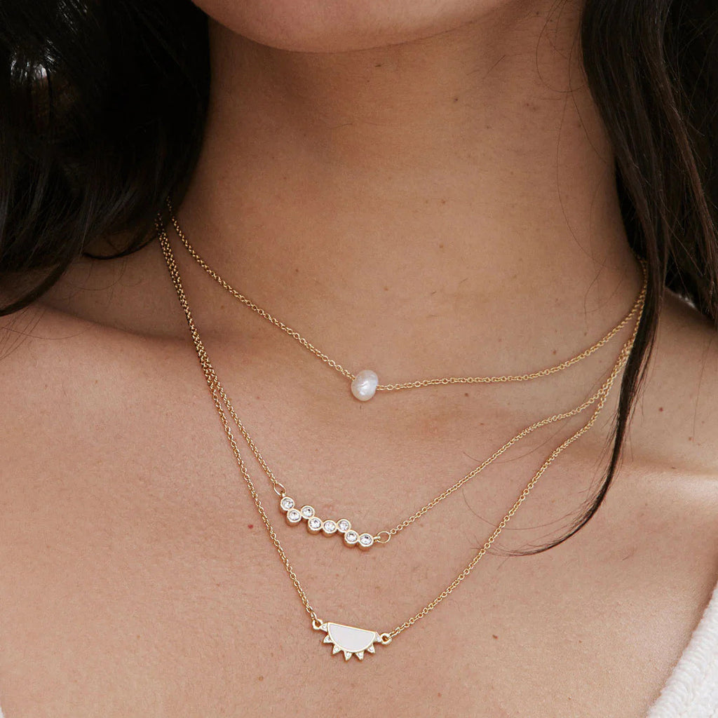 Cluster necklace styled between two other necklaces