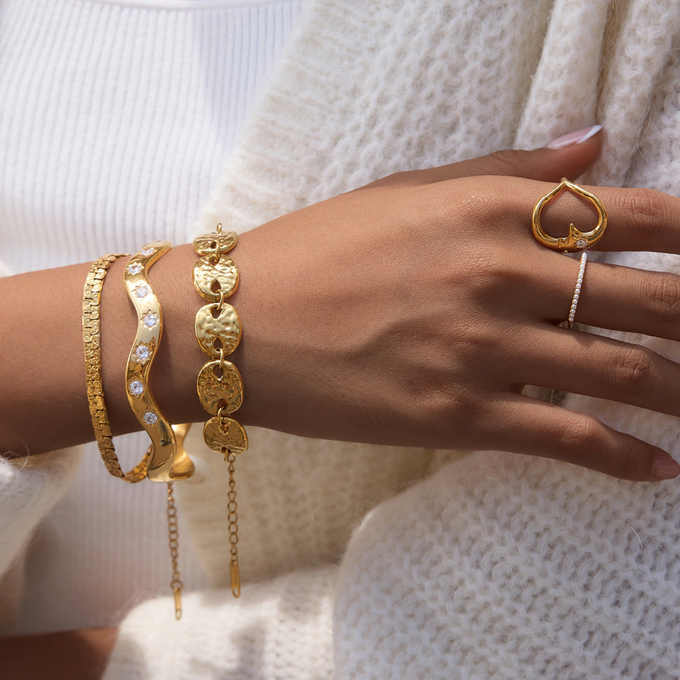 Moon-face ring styled with three gold tone bracelets