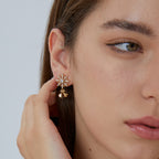 Snowflake and bell drop earrings shown worn on the ear