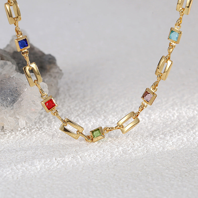 close view of multicolor square accents between open gold links