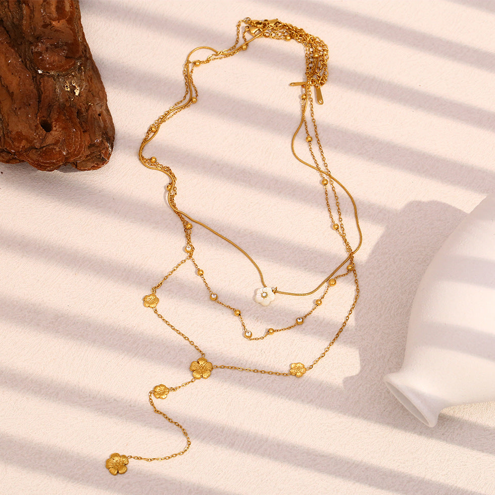 gold plated floral lariat necklace arranged in three graduated layers