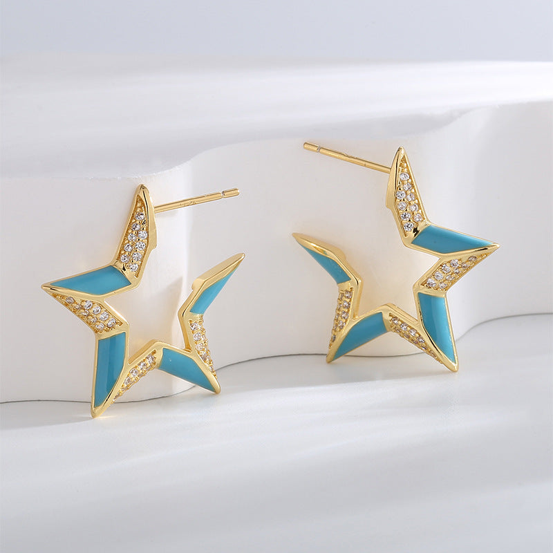 gold plated blue resin star zirconia stud earrings upright in studio