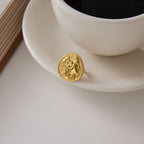 Oval portrait ring displayed beside a white cup