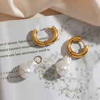 chunky gold hoop and white pearl drop earrings in a styled flat lay