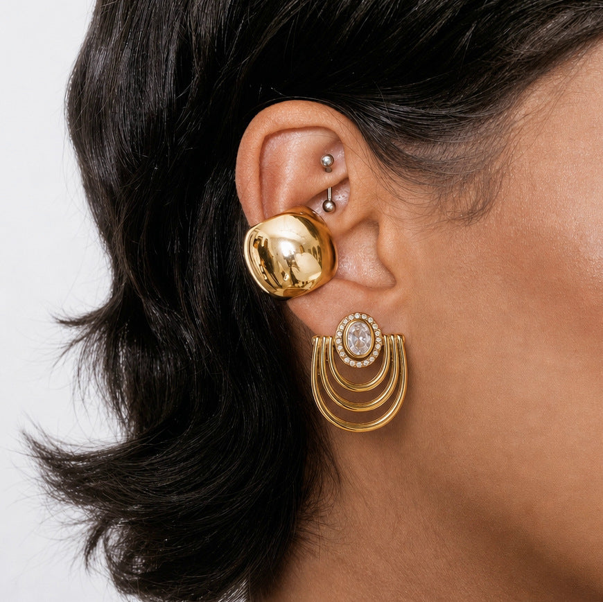 Graduated arc earring worn with a broad ear cuff