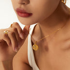 Round textured pendant necklace worn with separate earrings