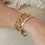 Two-tone link bracelet layered with silver tone cuff