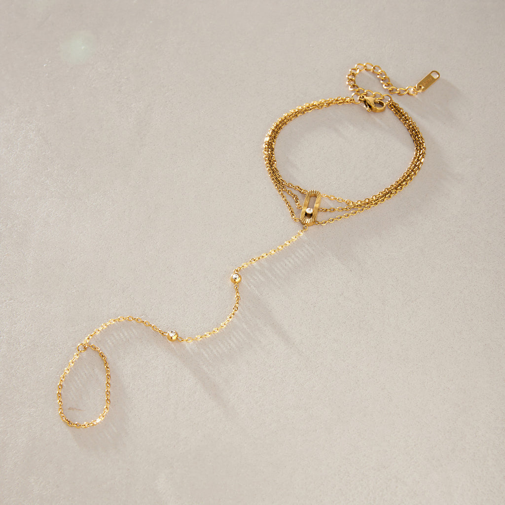 Fine hand chain bracelet laid out on stone