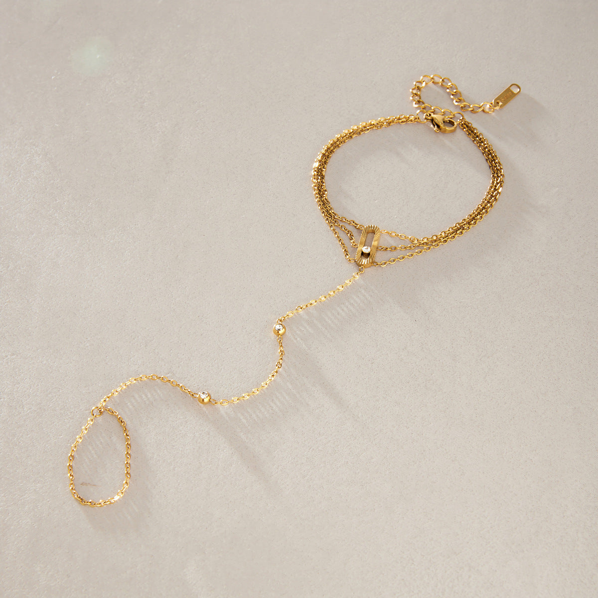 Fine hand chain bracelet laid out on stone