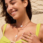 Cross and white imitation pearl layered necklace on model