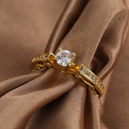 gold plated clear stone solitaire ring styled on brown satin