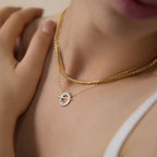 Close-up of circular halo pendant and horizontal bar when worn
