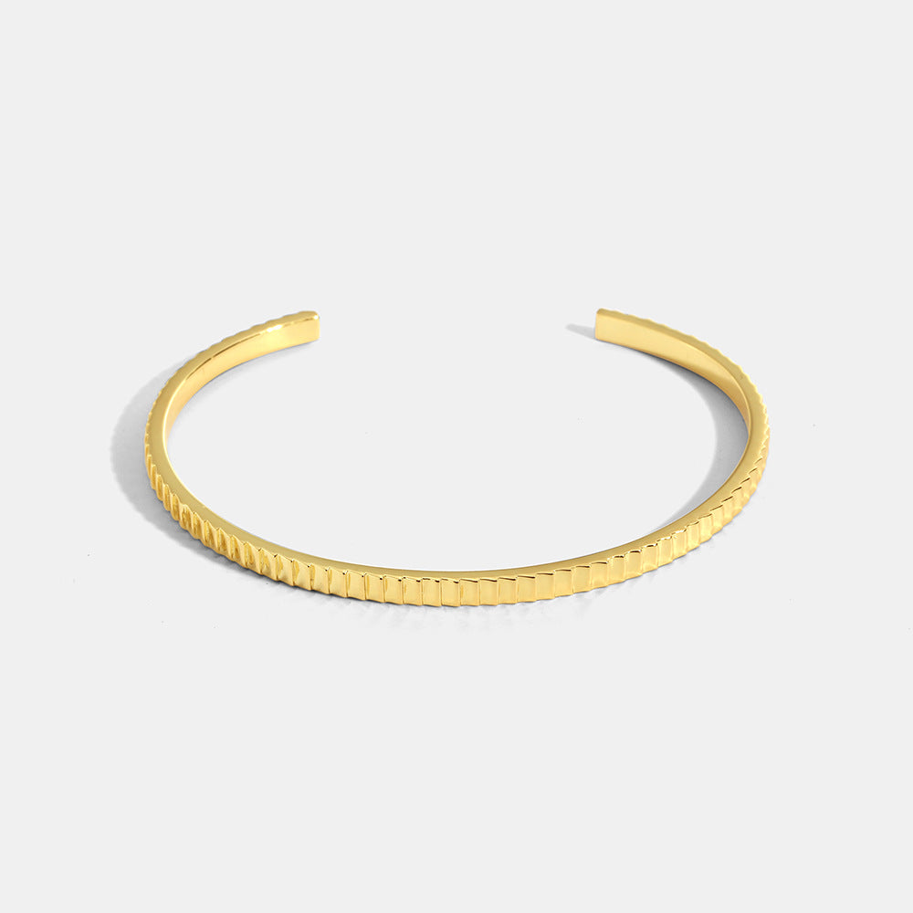 gold plated ribbed open cuff bracelet on white