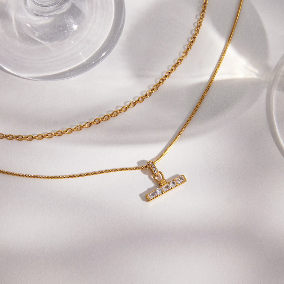 T-bar pendant and contrasting chain textures close-up