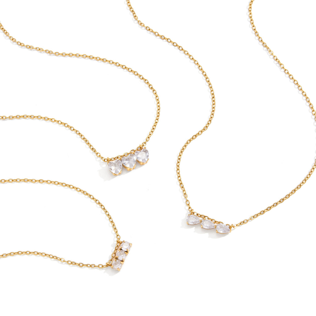 Gold plated necklace options arranged on white background