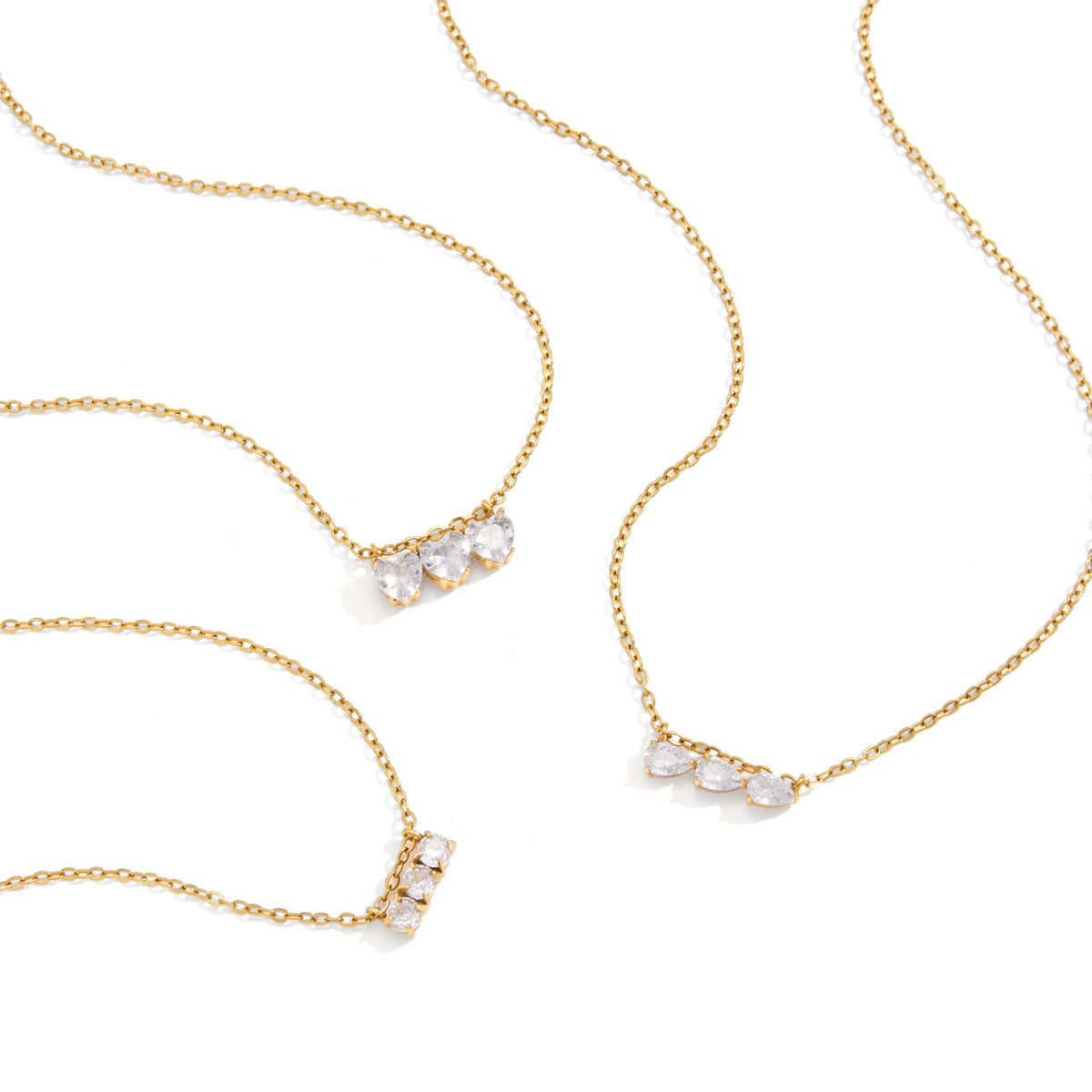 Gold plated necklace options arranged on white background