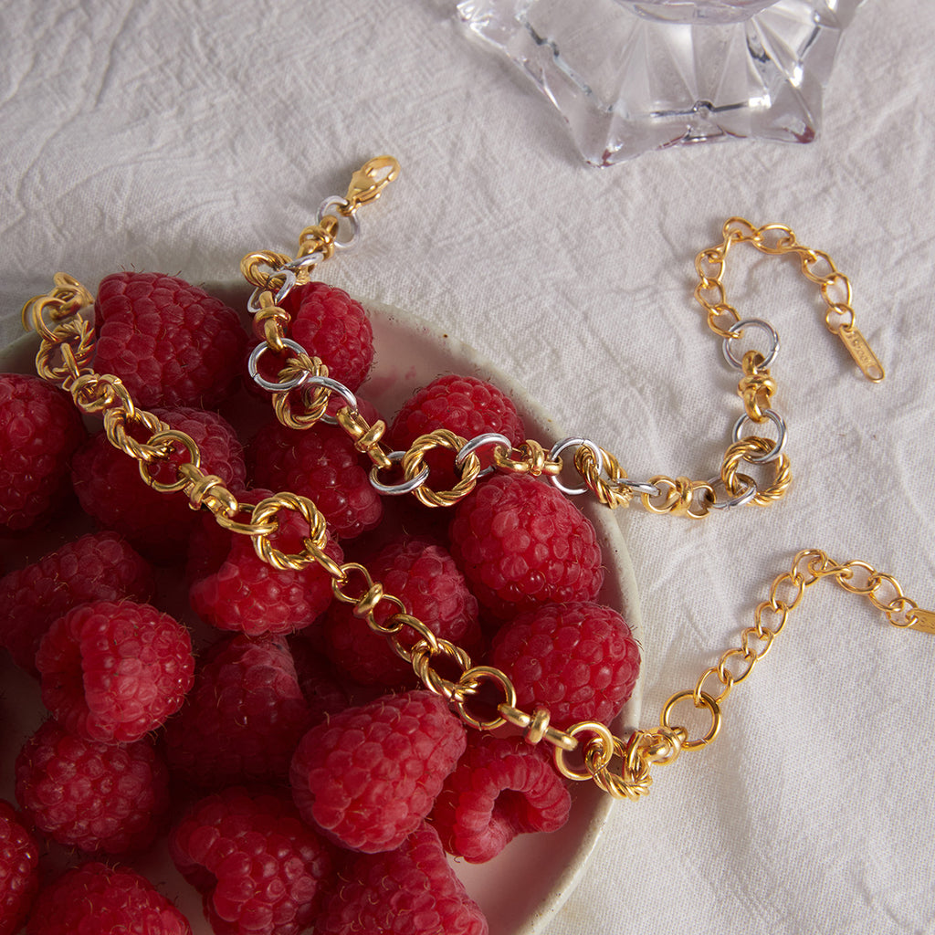 Gold tone and two-tone interlocking bracelets on fabric