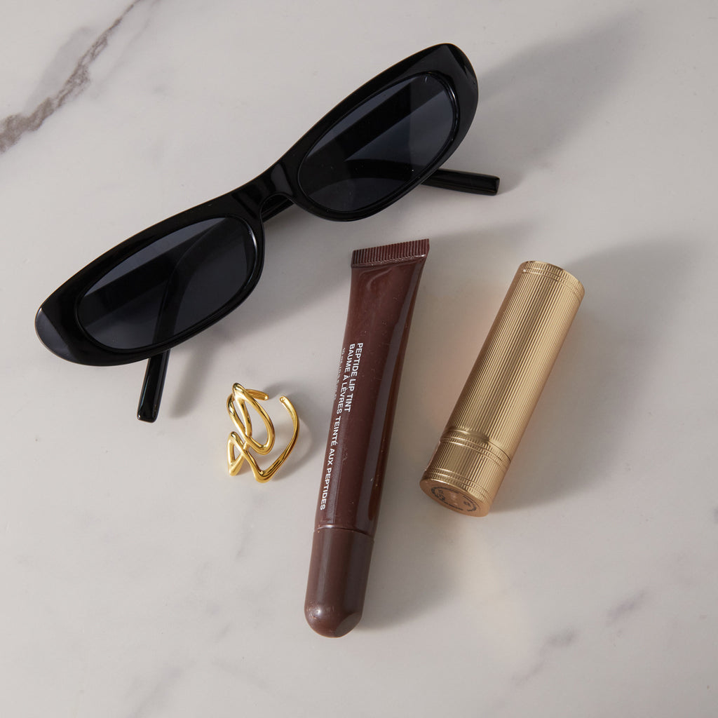 Abstract ring displayed beside sunglasses