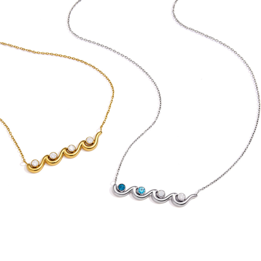 Gold and silver tone wave pendant necklaces laid flat