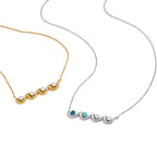 Gold and silver tone wave pendant necklaces laid flat
