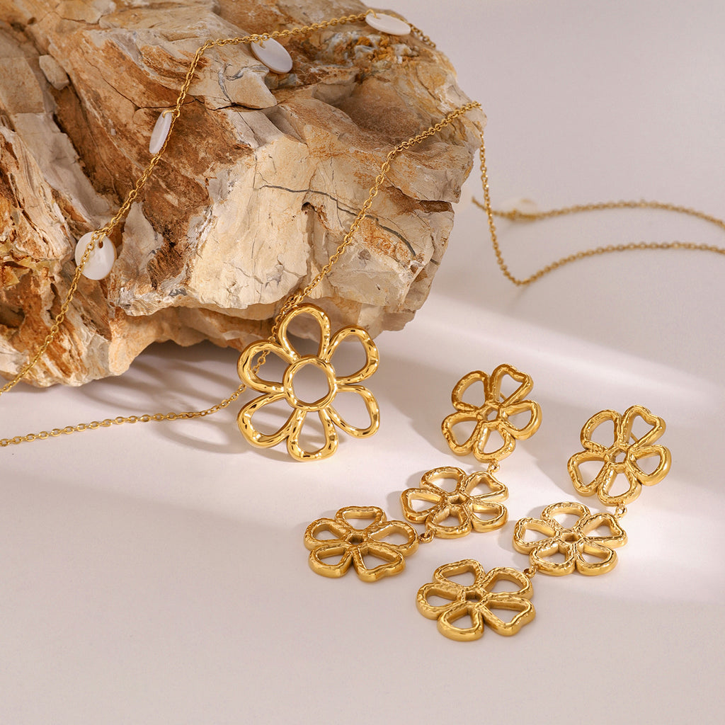 Linked flower earrings displayed on wood with other floral references