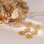 Linked flower earrings displayed on wood with other floral references