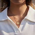 gold plated sunburst disc pendant necklace worn on model