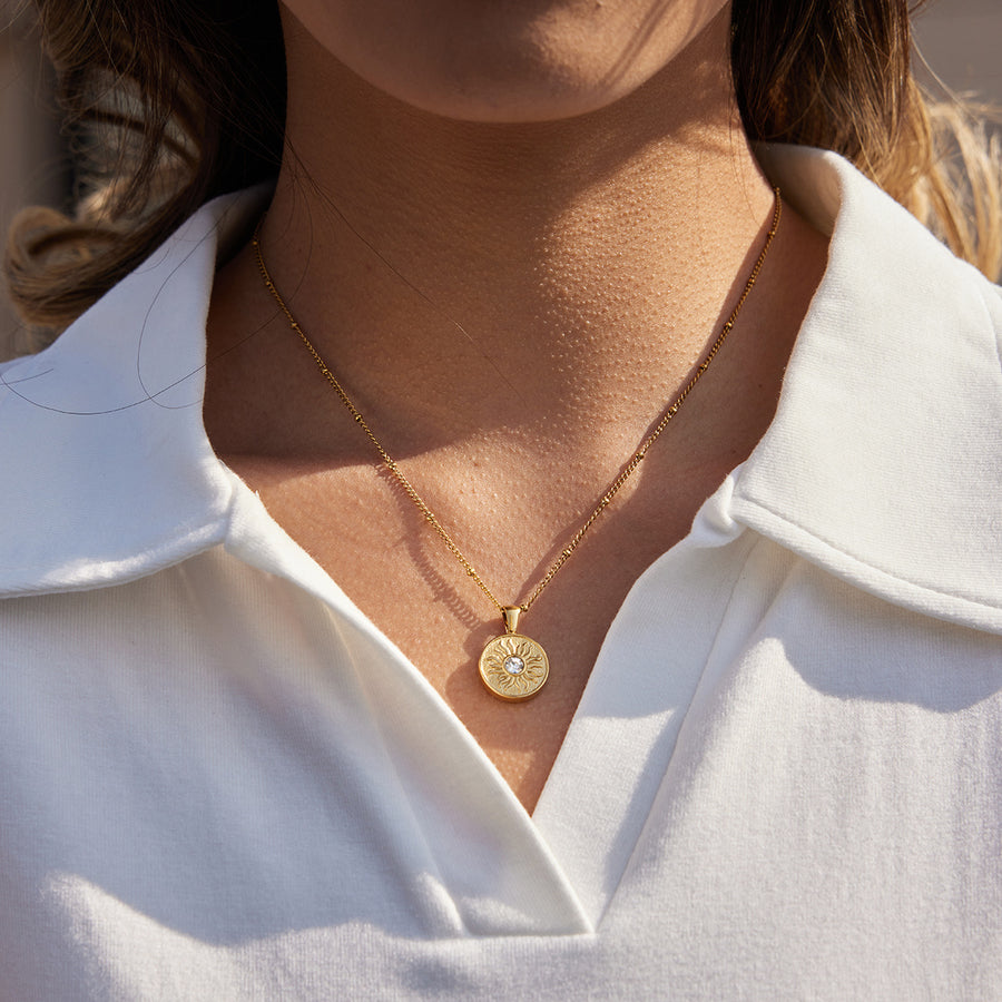 gold plated sunburst disc pendant necklace worn on model
