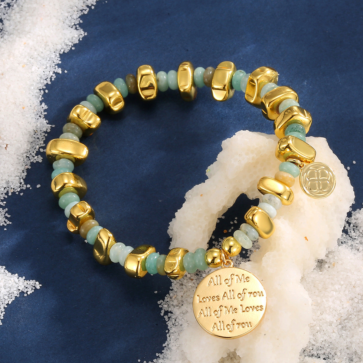 pale aqua and gold bead bracelet styled on navy fabric