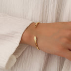 model wearing a slim asymmetric gold plated zirconia cuff