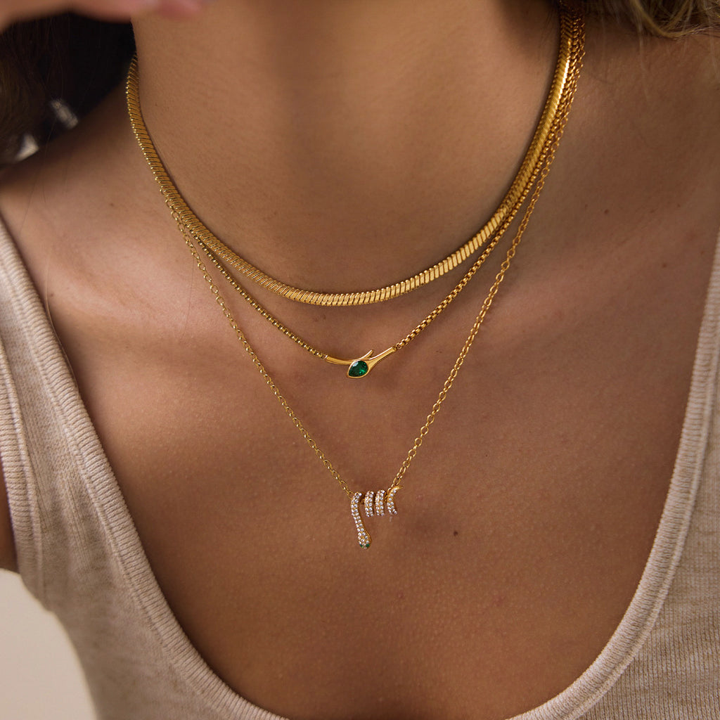 Close-up of layered snake pendant and green stone bar