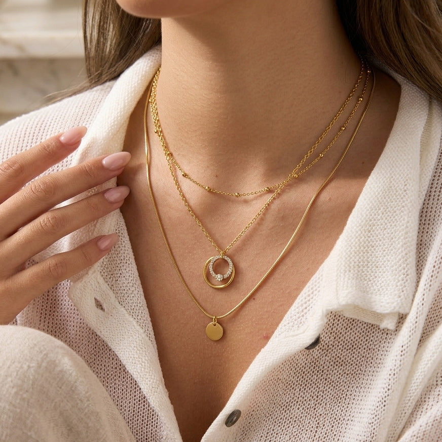 Circle pendant necklace layered with separate plain necklaces