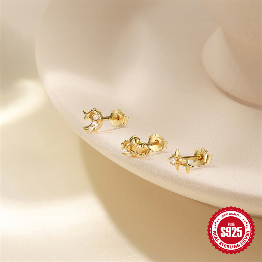 three petite celestial studs arranged on a cream display