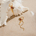 gold plated fish and bead tassel earrings styled by a shell
