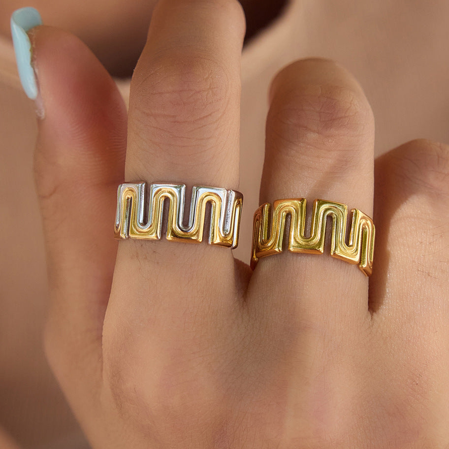 Gold tone and two-tone meander rings worn on fingers