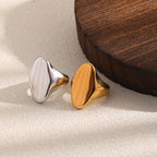Gold-tone and silver-tone organic oval rings on fabric