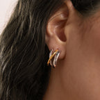 Two tone triple-curve earring worn close-up