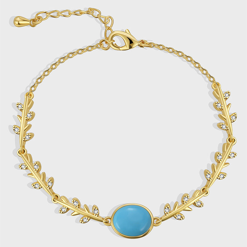 gold plated vine bracelet with turquoise-color oval center on white