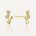 gold plated asymmetric clear stone bow stud earrings front and side view