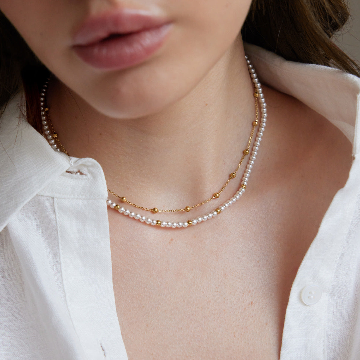 Two-strand white bead necklace with gold-tone details